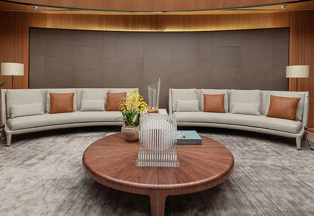 Living room of the new headquarters, with a light sofa and a round wooden coffee table.